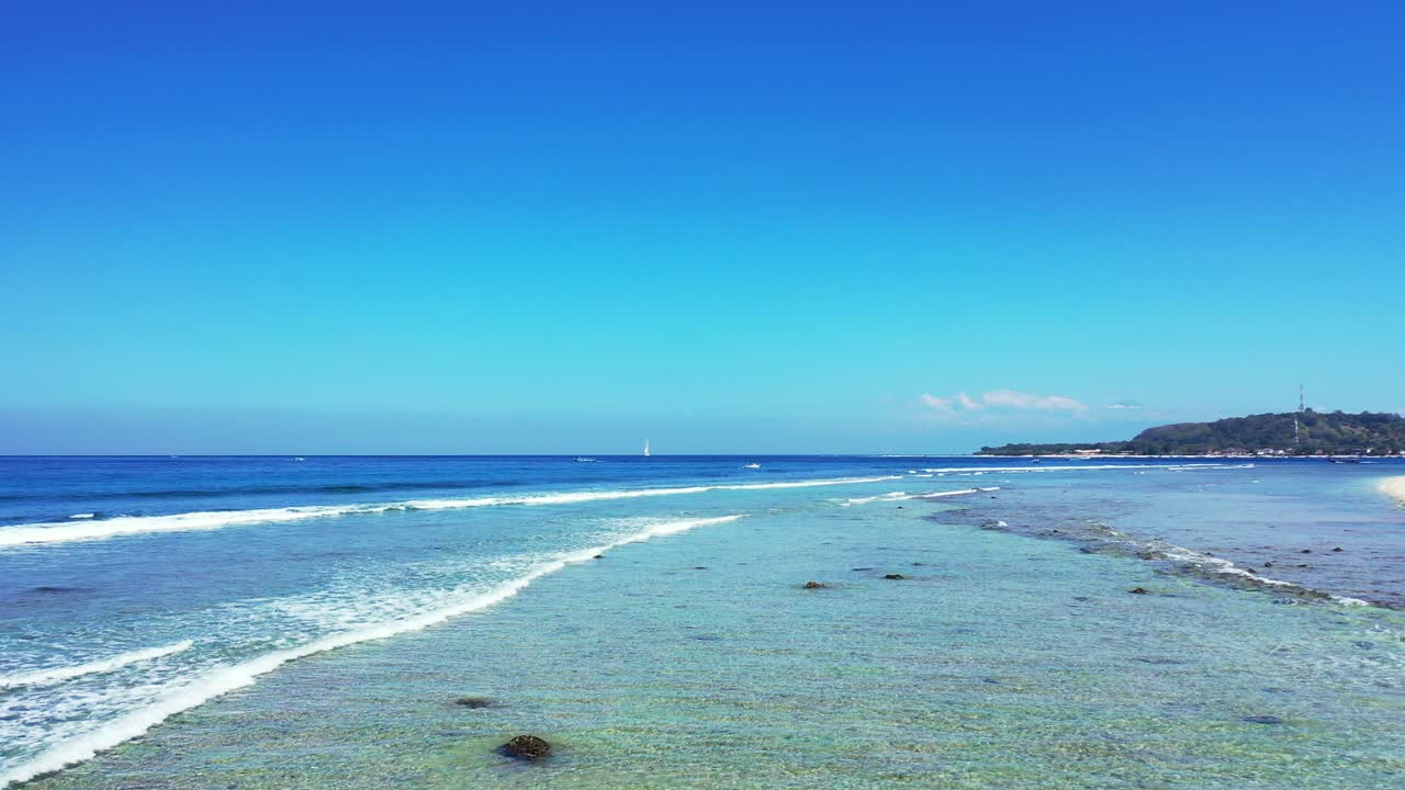 열대 섬 해안의 바위 바다 밑바닥을 씻는 하얀 파도, 인도네시아의 밝은 아침에 푸른 바다와 하늘이 있는 아름다운 바다 풍경