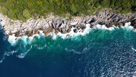sea waves splashing and foaming on big cliffs in beautiful dramatic seaside of mediterranean in albania
