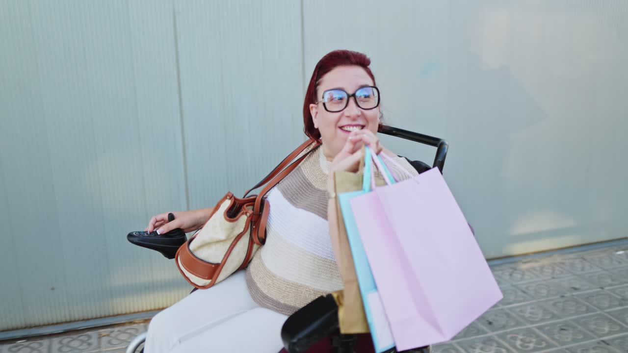 Mujer feliz en silla de ruedas motorizada con bolsas de compras en una calle de la ciudad