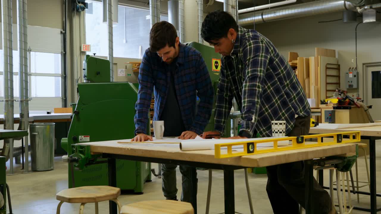 carpinteros discutiendo sobre el proyecto en el taller 4k