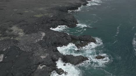 Atlantic-Ocean-merges-with-volcanic-field,-aerial-view