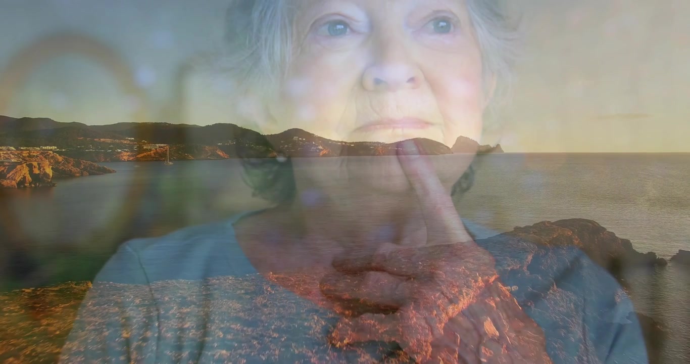 Senior woman touching chin while coastal sunset landscape fading in showcasing wellness reflection