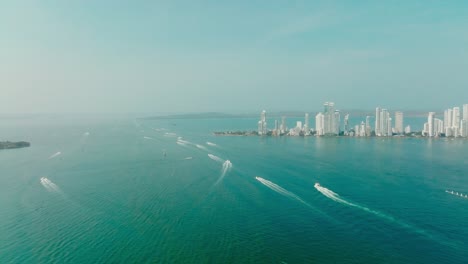 Toma-Aérea-De-Muchos-Barcos-Navegando-Hacia-El-Océano-Saliendo-De-La-Ciudad,-Cartagena,-Colombia