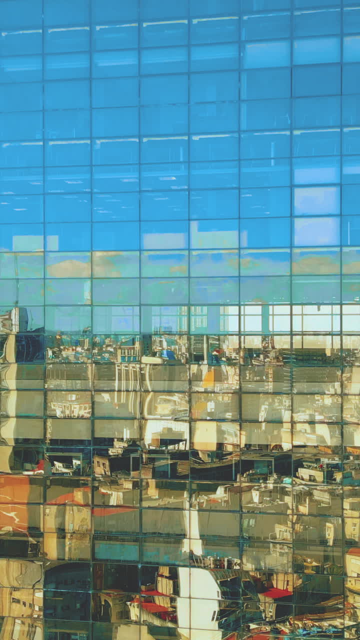 City Skyline and Blue Sky Reflected on Modern Glass Building Facade