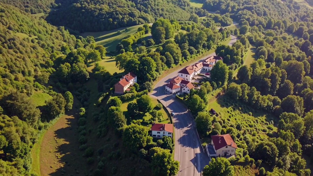 Luftfoto af en lille landsby i en frodig grøn dal