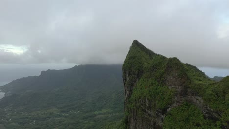 Aerial-shot-flying-alongside-a-huge-cliff-in-the-mountains-of-Mo'orea-island,-French-Polynesia