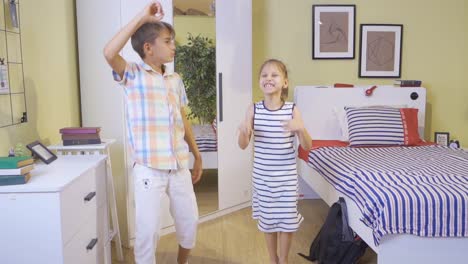 hermana y hermano niño. ella está bailando en la habitación.