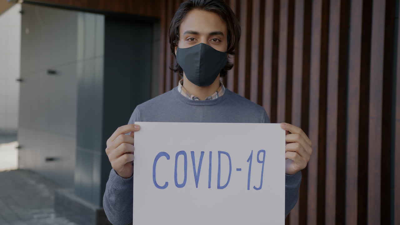Man holding a COVID-19 sign