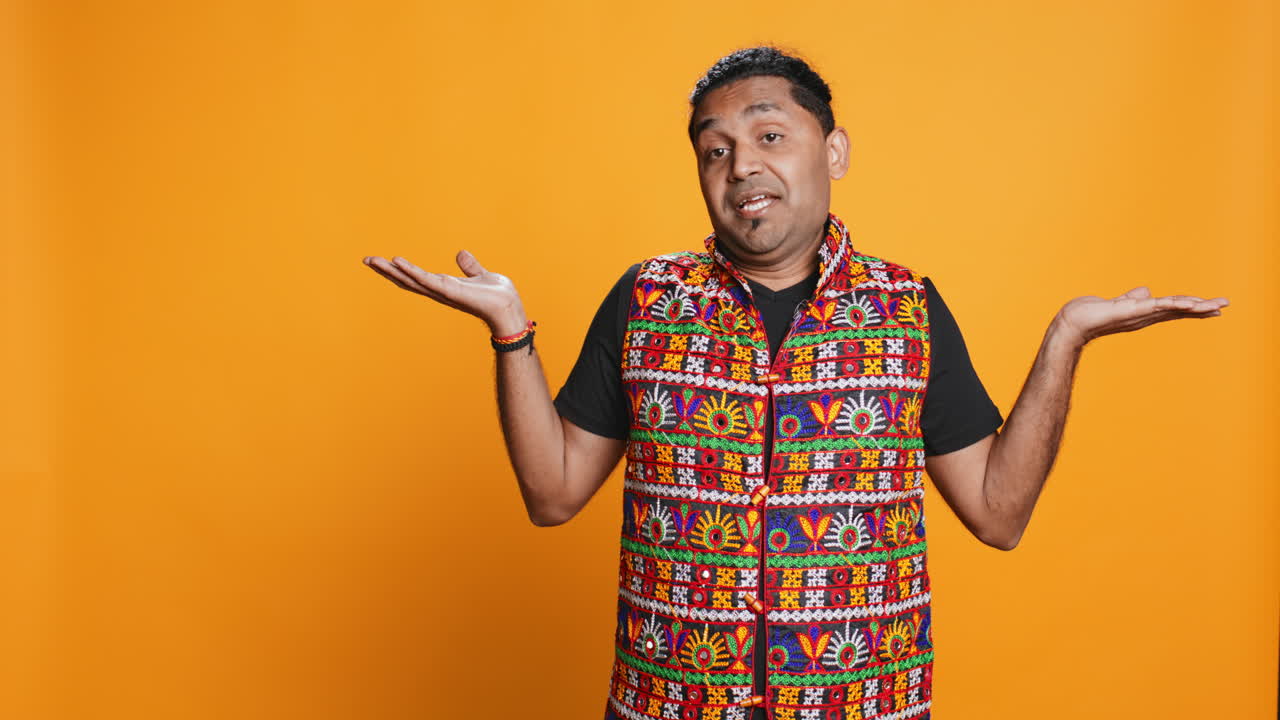 Man shrugging shoulders, unable to provide answer, studio background,