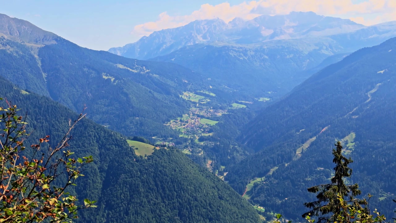 Atemberaubendes Luftpanorama, das die Stadt Caderzone Terme zeigt, eingebettet in ein üppiges grünes Tal, umgeben von den majestätischen italienischen Alpen