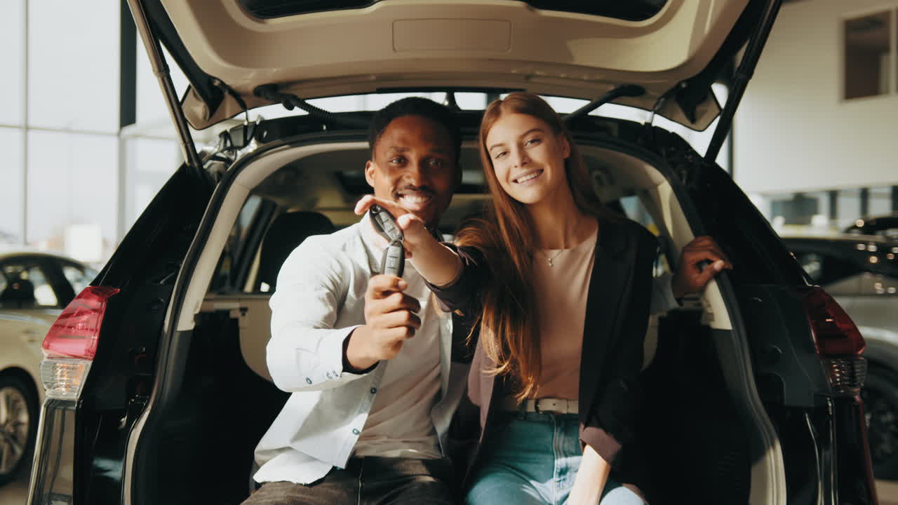 una pareja feliz con las llaves de un coche nuevo.