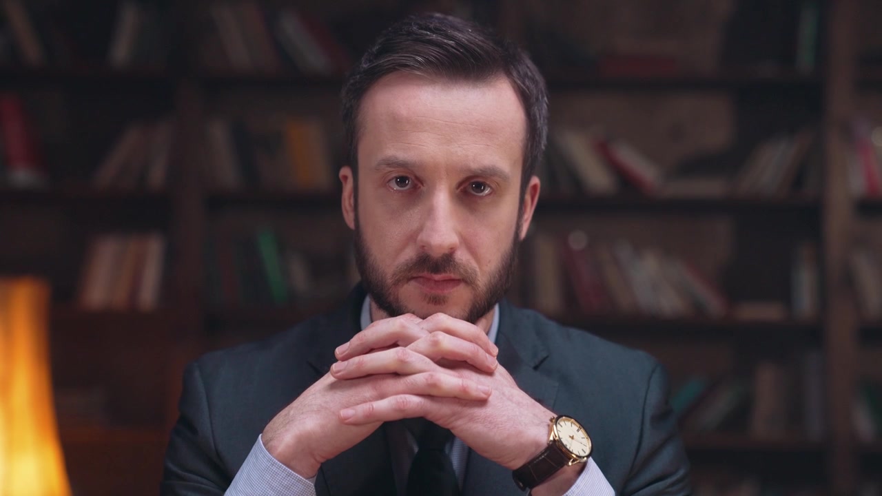 Uomo professionista apre gli occhi con espressione seria in biblioteca