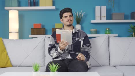 un joven concentrado leyendo un libro. pensativo.