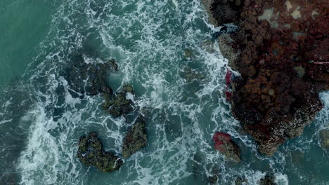 las olas salpicando las rocas de la orilla del mar