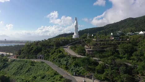 antena que se eleva por encima de la estatua de buda más alta y templos con enormes montañas y océano en da nang, vietnam