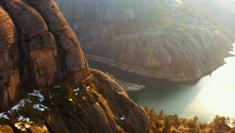 Aerial-view-of-Rock-mass,-river-flows-at-the-foot-of-the-rocky-mountains,-sunny-day