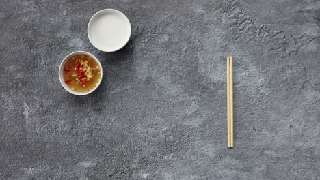 male hands picking up tofu noodle asian cuisine meal from flay lay surface