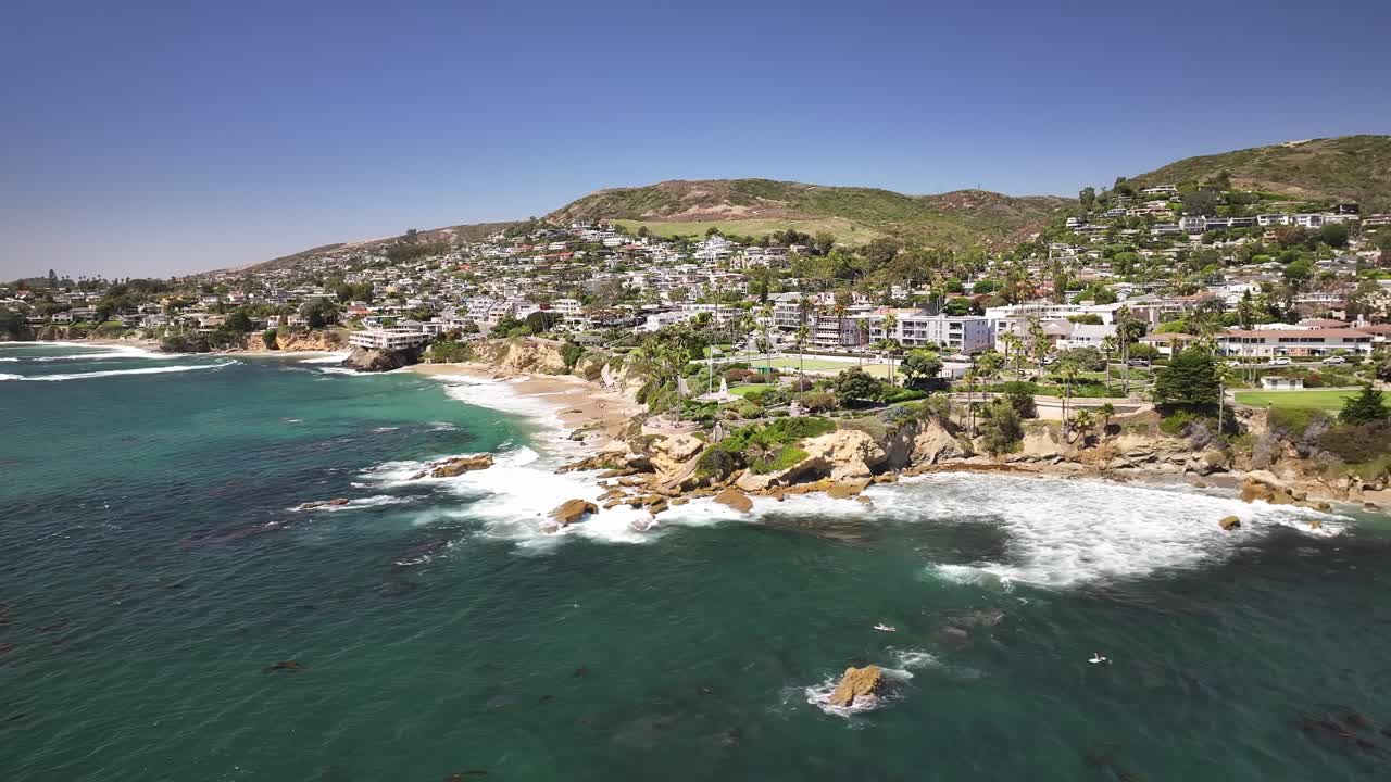 Laguna Beach California aerial drone view of the Pacific Ocean, cliffs, rocks, palm trees, and big waves
