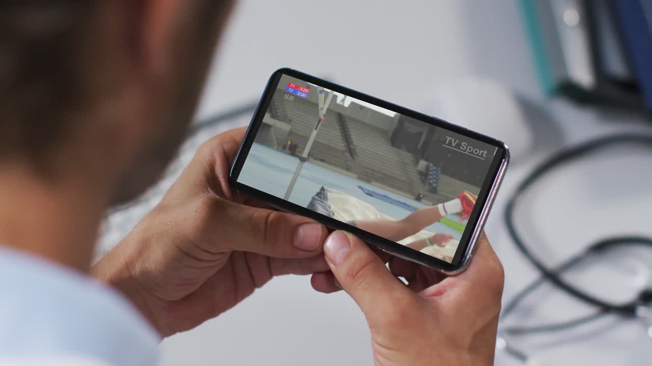 스마트폰으로 육상 높이뛰기 경기를 시청하는 남성 의사의 복합 사진