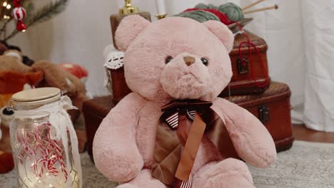 plush teddy bear with striped bow tie amidst vintage christmas decor