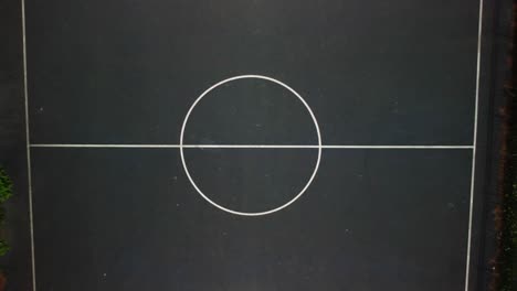 Aerial-shot-revealing-a-basketball-court,-camera-facing-down