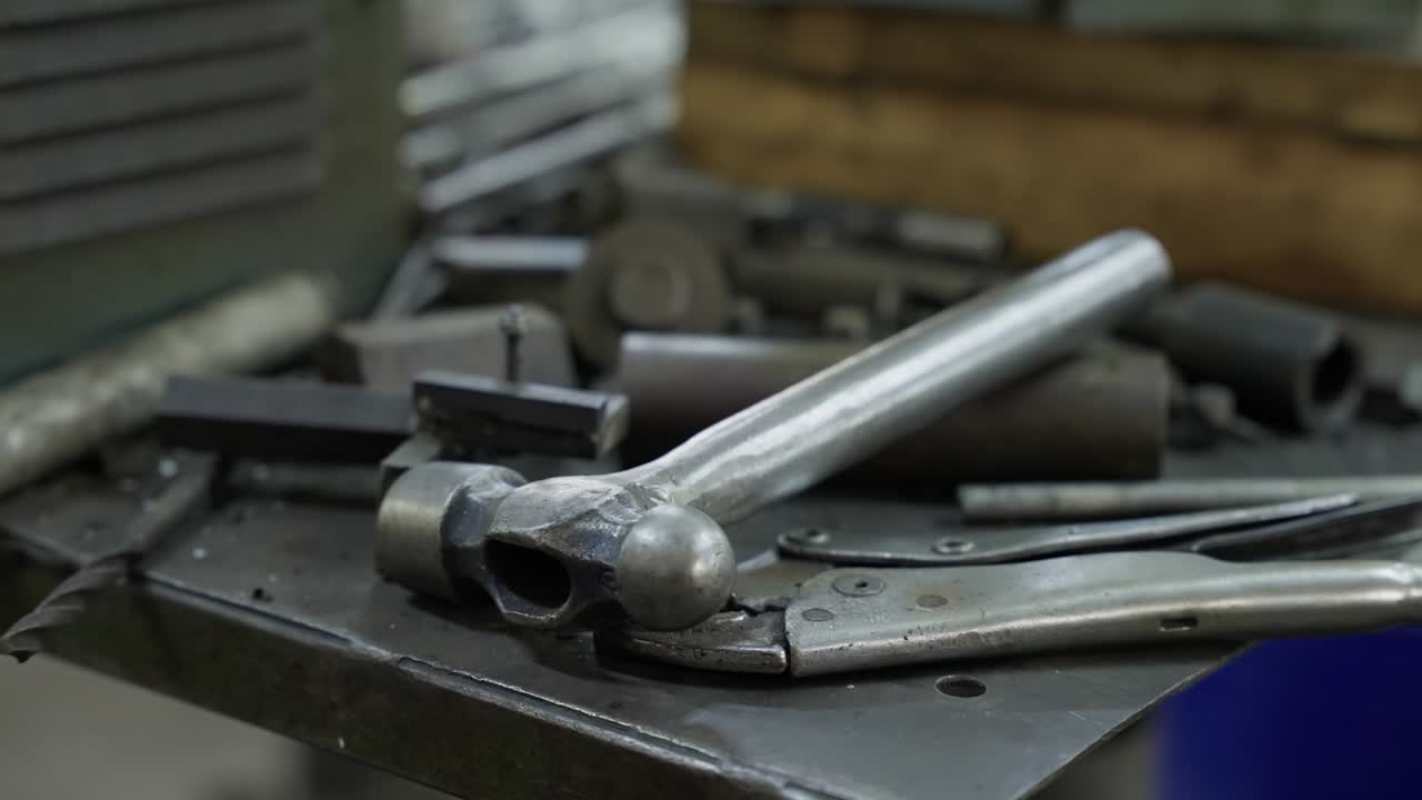freshly welded part with tools and scrap metal on industrial workbench surface