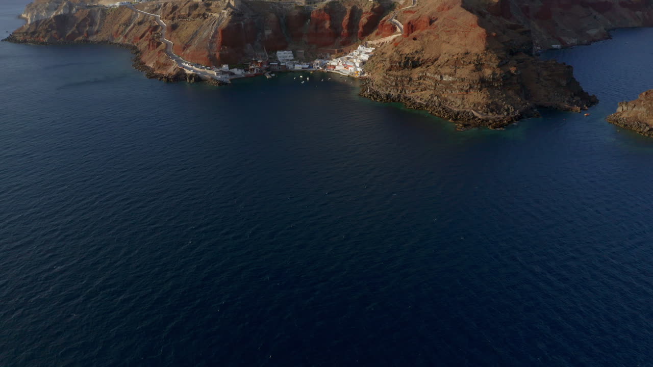 inclinación aérea panorámica revela toma de oia en santorini, grecia durante la puesta de sol, 4k prores