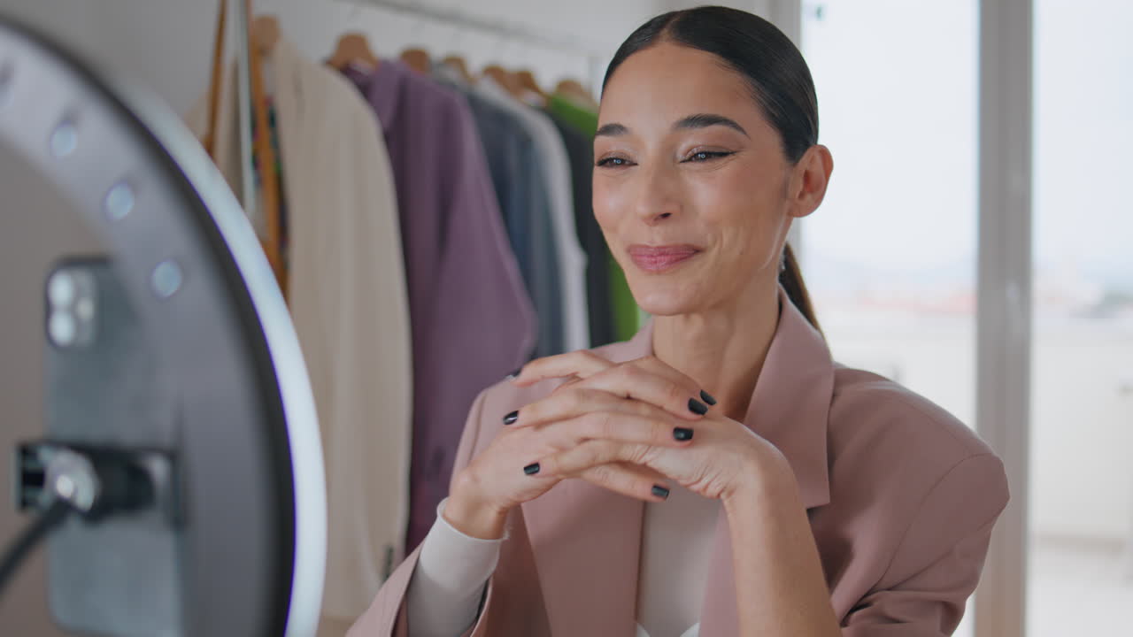 웃는 블로거가 집 근접에서 스마트폰을 보고 웃는 여성 스트리밍