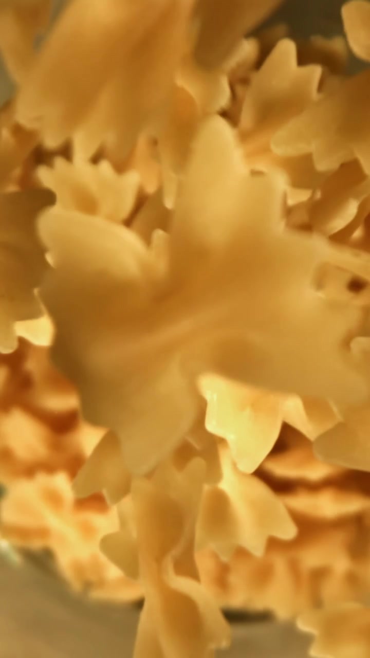 Farfalle Crude che Cadono in un Contenitore