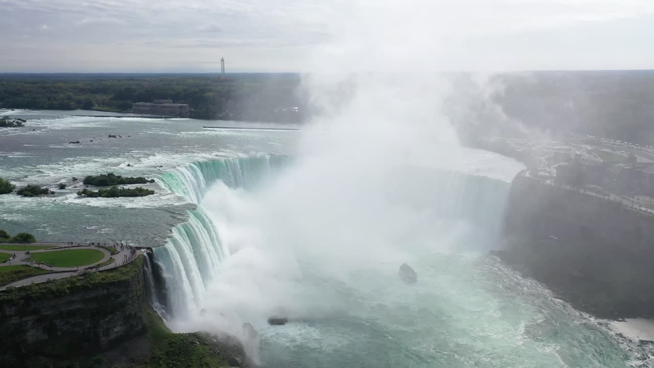A breathtaking aerial view of Niagara Falls’ Horseshoe Falls, showcasing cascading water, mist, and the lush surrounding landscape. Perfect for travel, nature, and scenic destination content.