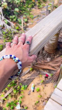 woman with jewelry at a wooden beach path