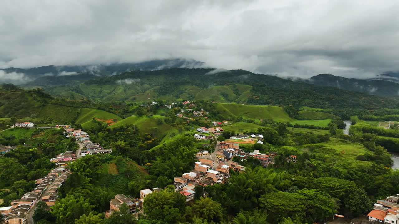 Vista aérea de casas e estradas nas montanhas de San Rafael, Colômbia, sob um céu nublado.