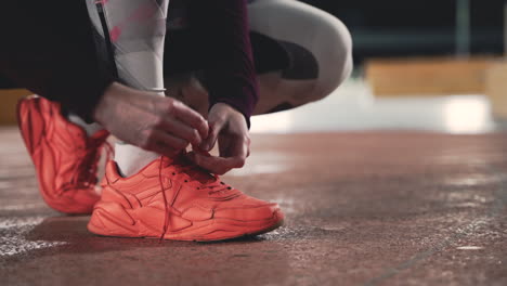 close up of sportswoman tying her shoelaces during her running session at park at night