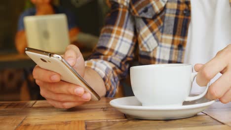 Mann-Trinkt-Kaffee,-Während-Er-Im-Café-4k-Sein-Mobiltelefon-Benutzt