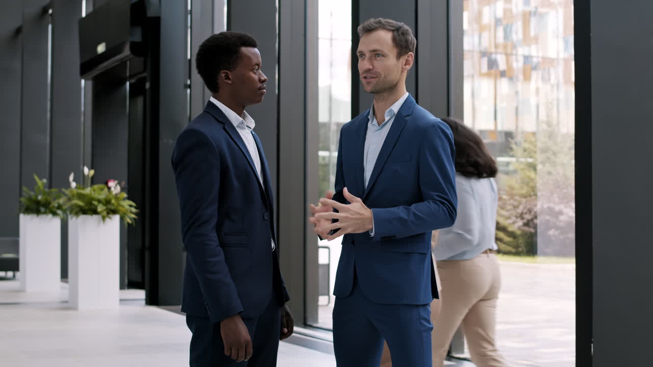 Two Businessmen Talking in Office Hall