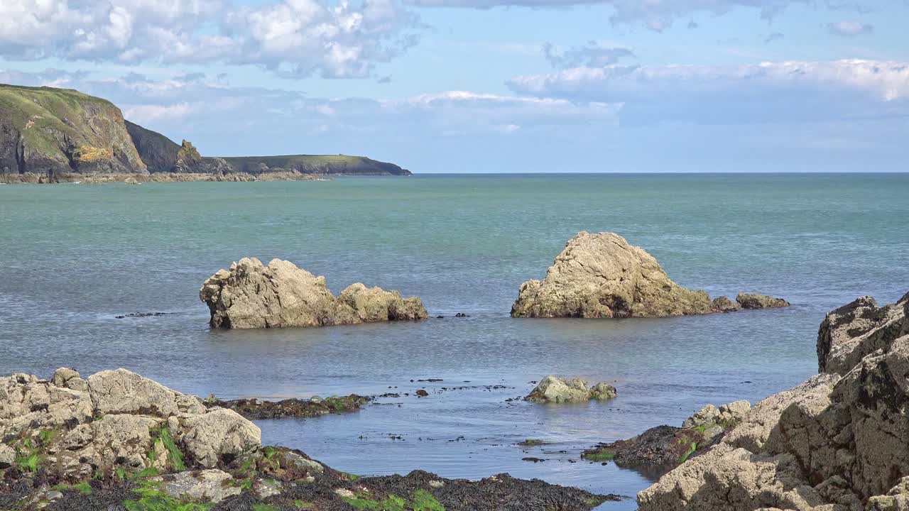 아일랜드의 서사시적인 장소, 평온한 에메랄드 바다, 들어오는 조류, 그리고 놀라운 바다 절벽, 워터포드 해안선의 자연 아름다움, 구리 해안 전망.