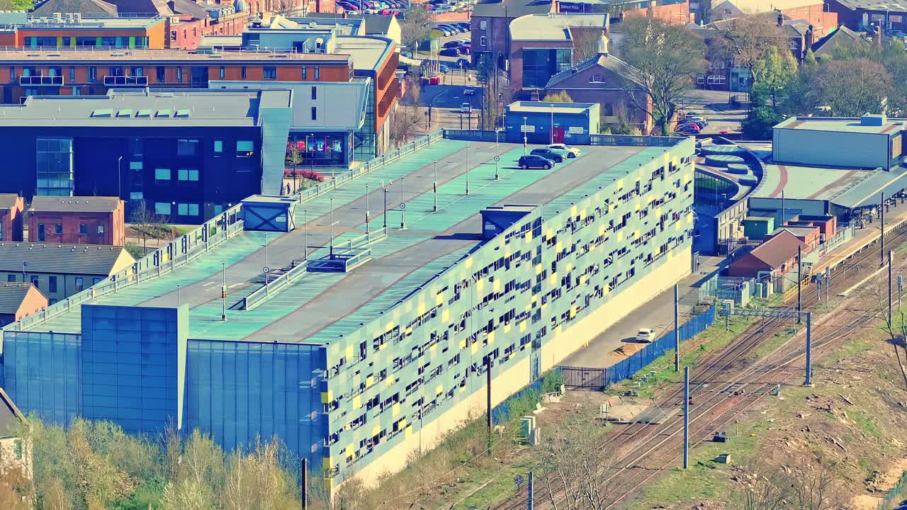 Aerial view over Wakefield train station, Yorkshire, England, with urban buildings and traffic in motion.