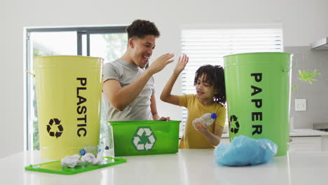 biracial father and son recycle at home, with copy space