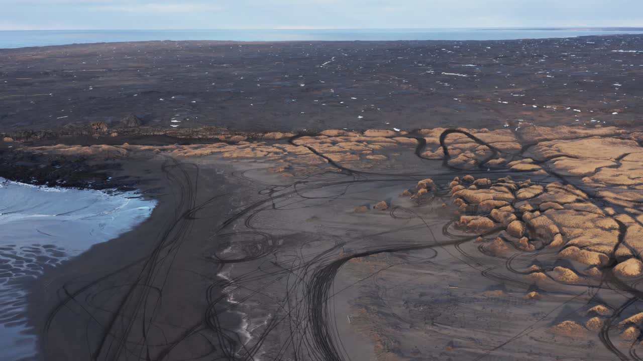 пляж сандвик из черного вулканического песка с травянистыми дюнами в исландии, аэрофотосъемка
