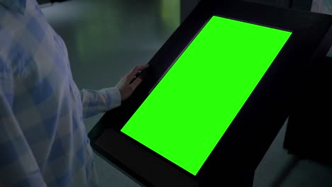 concepto de pantalla verde - mujer mirando en blanco interactivo kiosco de visualización verde