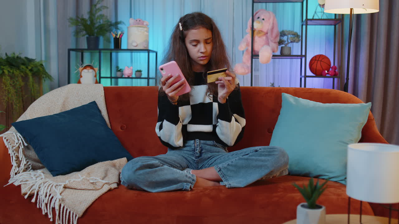 niña encantadora usando tarjeta de crédito y teléfono inteligente transfiriendo dinero compras compras en línea