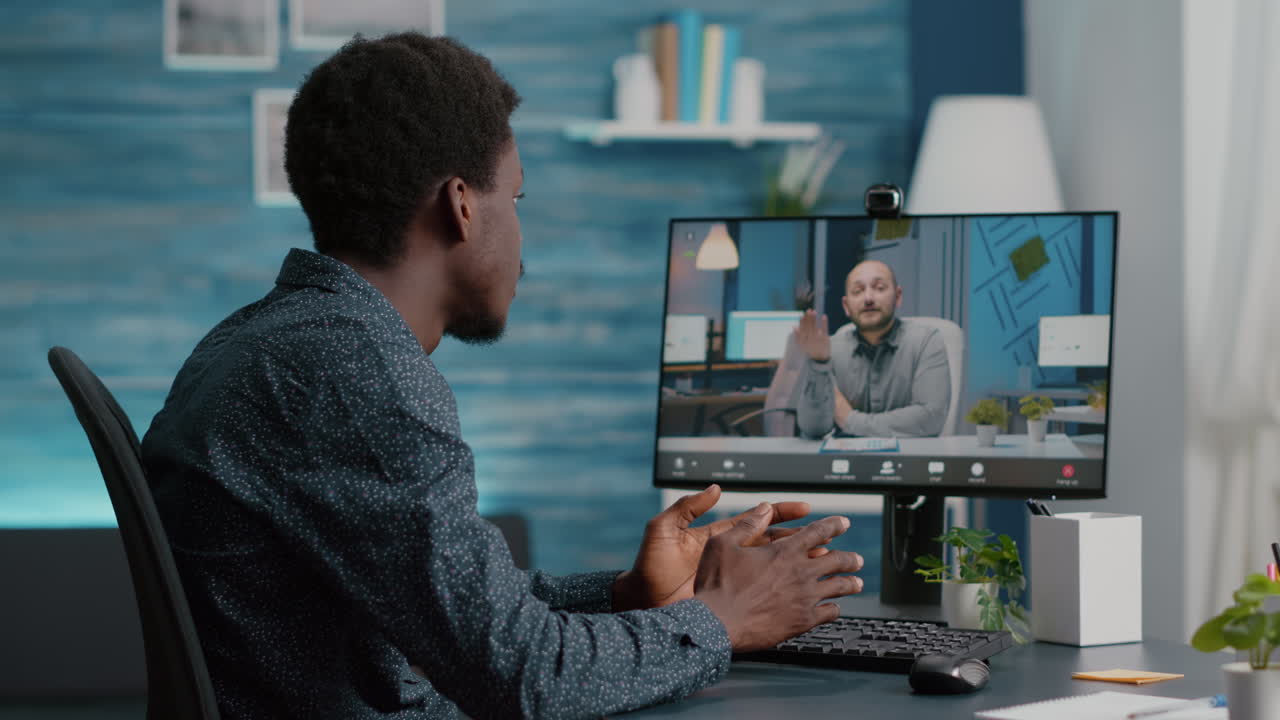 Selective focus on black guy using online conference video call talking with his work colleague