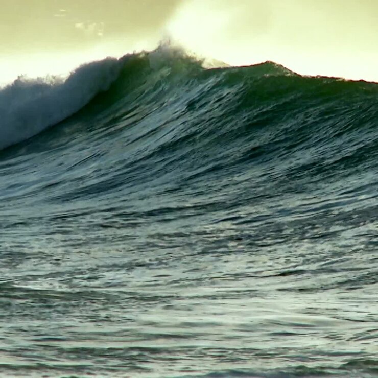 A photographer follows large waves as they crest and break in slow motion 1