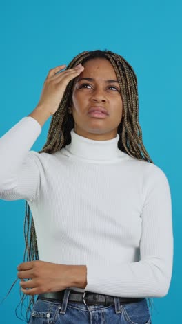 woman with headache on blue background