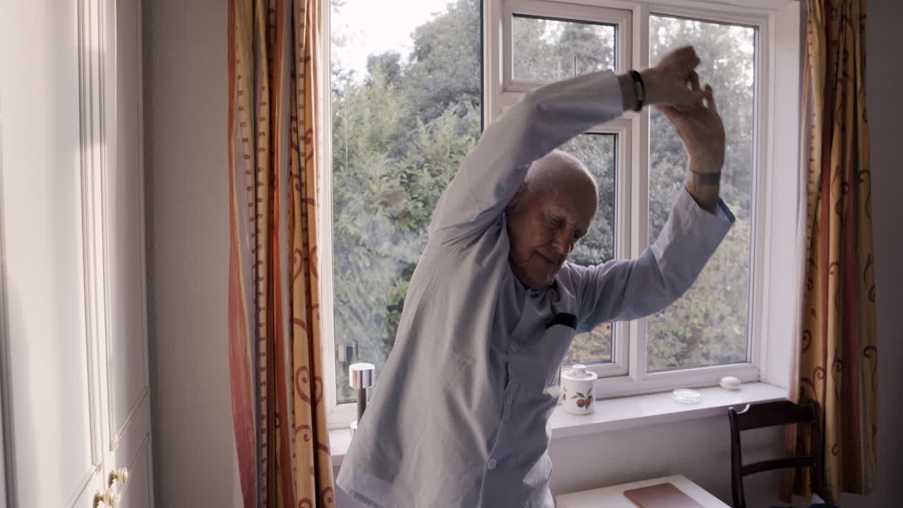 Senior man stretching in a bright room