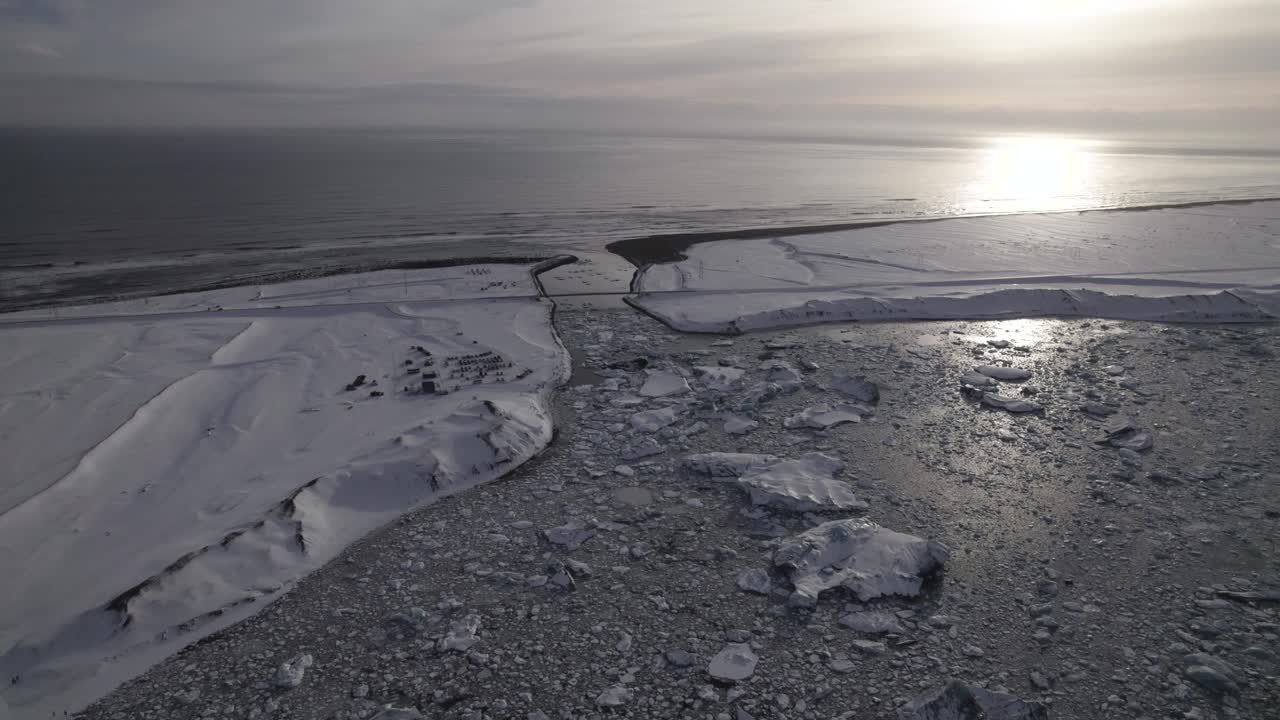 зимний пейзаж с пенным океаном и вулканическим пляжем с черным песком