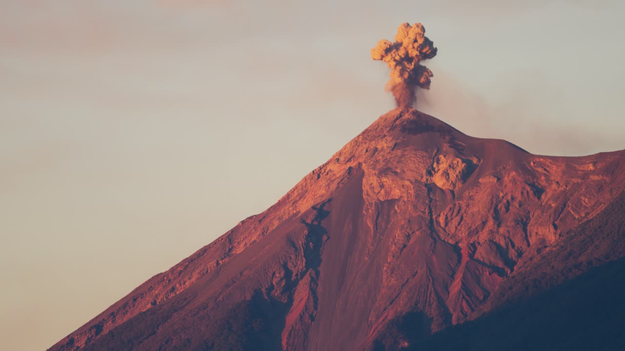 The Volcan de Fuego volcano erupting at sunrise as seen from Antigua, Guatemala