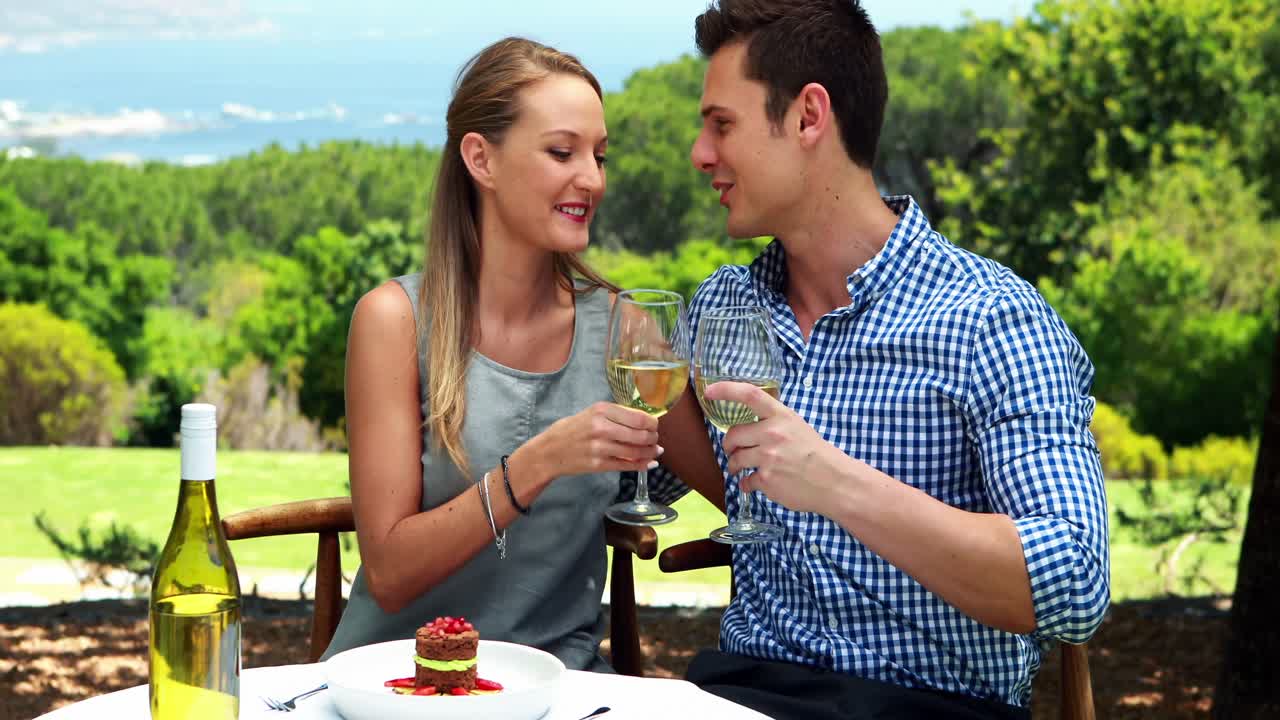 pareja brindando copas de vino en un restaurante al aire libre 4k