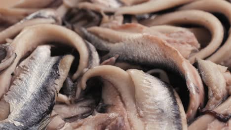 fresh sea sardines and anchovy fish and mullus on display on ice on market store shop. seafood fish background, close up stand of small salty white fish.