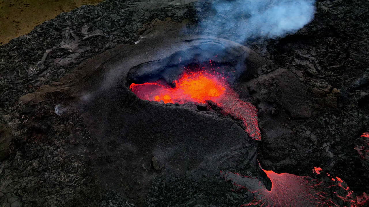 toma aérea hacia atrás de la lava caliente, el magma y las cenizas que salen de la boca del cráter en fagradalsfjall, islandia